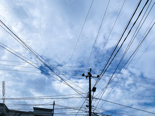 electricity pylons with wires running across them against a blue sky background