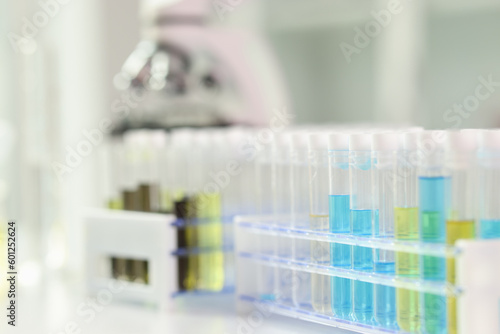 Test tubes with colourful liquid, microscope on background