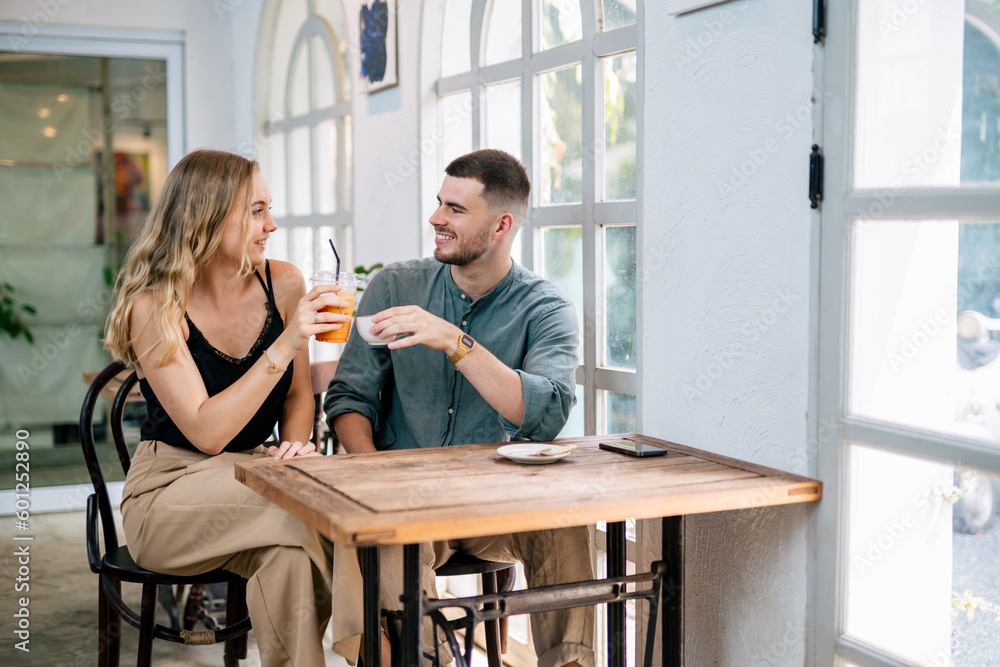 Couple celebrating success with tea and coffee together at cafe table. Couple celebrating success with tea and coffee together at cafe table.