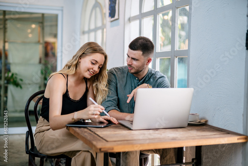 Happy caucasian couple using laptop on living room table at home. The concept of couples sharing one idea together..