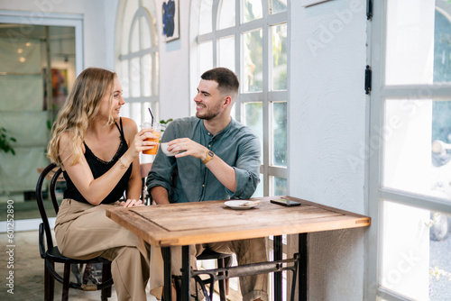 Couple celebrating success with tea and coffee together at cafe table.