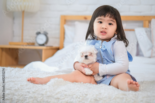 Little girl's tender touch and the dog's gentle wag of the tail were gestures of affection reaffirming their deep bond and shared happiness. photo