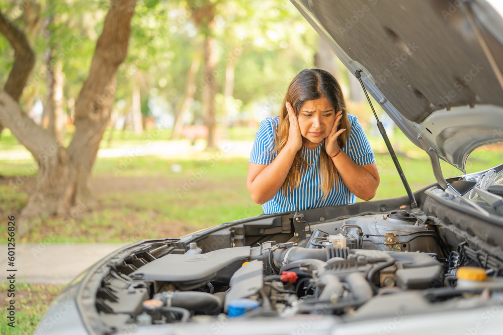 woman shows helplessness at the sight of her car engine not running