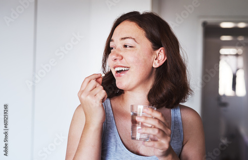 Fotografie Healthcare, medication and woman drinking a pill with a glass water for wellness at her home