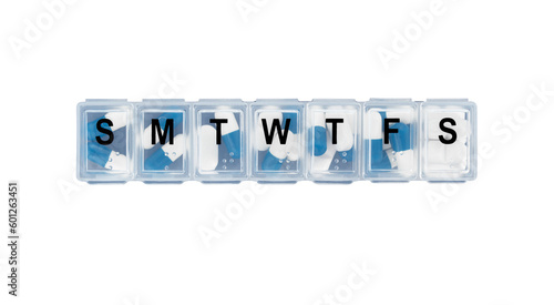 Daily pill box filled with daily doses of pills isolated on white background.