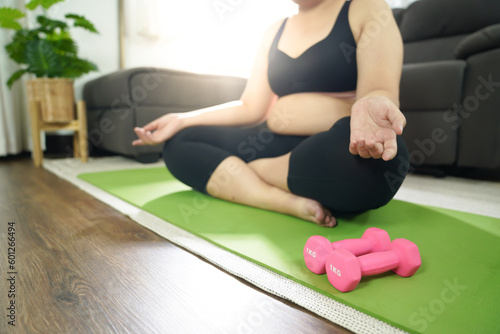 Overweight woman exercising for weight loss. exercise with dumbbells in stretching positions at home in the living room Cheerful Fat woman diet healthy lifestyle concept.