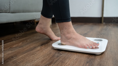 feet standing on electronic scales for weight control. Measurement instrument in kilogram for a diet control