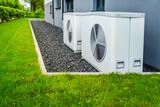 Two air source heat pumps installed outside of new and modern city house