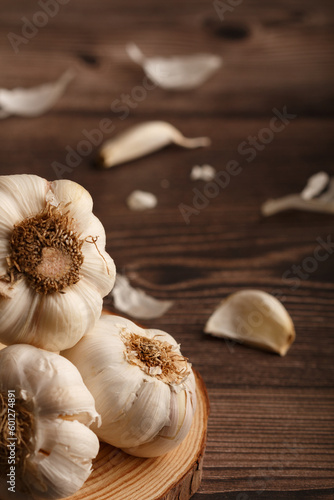 Head of garlic with cloves on a pine round wood slice. Rustic Table.  Copy space. Close up