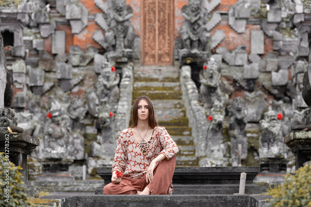 A slender female model poses during a summer tourist vacation with a view of the temple. The concept of summer Holidays, Indonesia, Relaxation and Spa