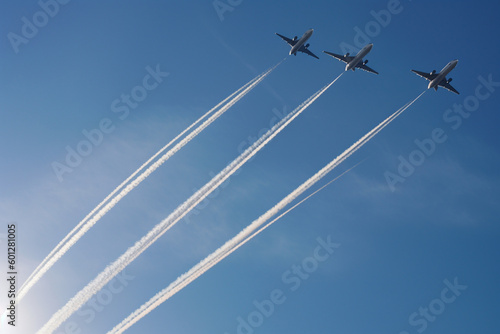 4 commercial passenger jets with condensation trails against a blue sky - congestion