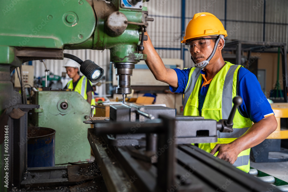 Asian worker wearing safety glasses working on a lathe machine. factory safety protection concept. Asian worker wearing safety glasses working on a lathe machine. factory safety protection concept.