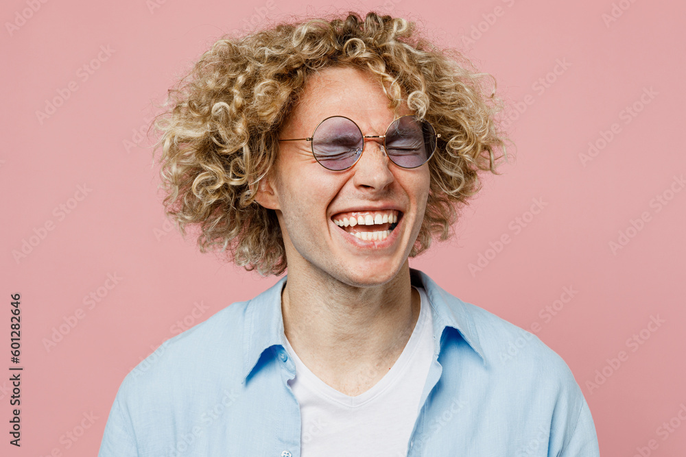 Close up young excited happy exultant cheerful blond man wears blue shirt white t-shirt sunglasses close eyes scream isolated on plain pastel light pink background studio portrait. Lifestyle concept.