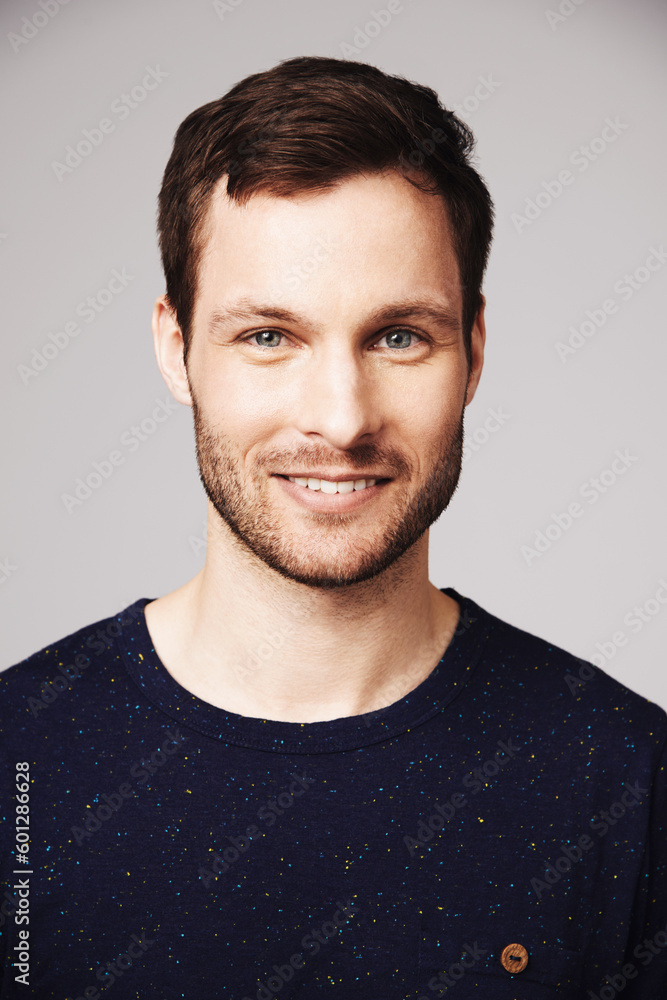 Obraz premium Man, portrait and smile of a happy person with confidence and casual style in a studio. Isolated, gray background and face of a male model and young person with modern fashion and stylish clothes