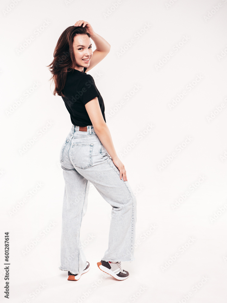 Young beautiful woman. Trendy carefree model in casual summer black T-shirt and blue jeans. Positive female isolated on white in studio. Cheerful and happy. Copy space, mockup. Turns around Young beautiful woman. Trendy carefree model in casual summer black T-shirt and blue jeans. Positive female isolated on white in studio. Cheerful and happy. Copy space, mockup. Turns around