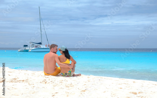 a couple of men and women on a boat trip to Small Curacao Island with a white beach and turqouse colored ocean