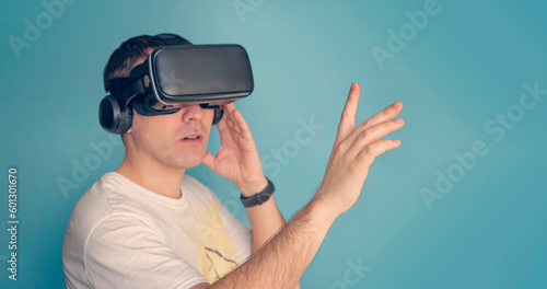 Man looking vr box on blue background, Virtual Reality Glasses, cardbox. Waist up. People and technology metaverse concept. viewing 360 videos © diy13