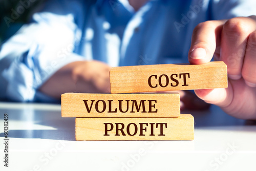 Tablou pe pânză Close up on businessman holding a wooden block with Cost Volume Profit message