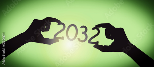2032 - human hands holding black silhouette year number