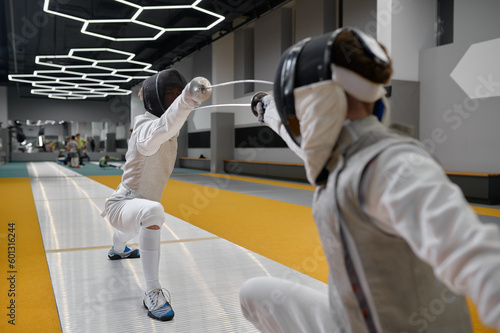 Fotografie Duel of fencers during fencing match, training lesson at martial art class