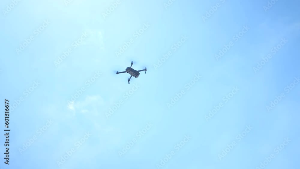 Drone flying in circles against a blue sky background Drone flying in circles against a blue sky background