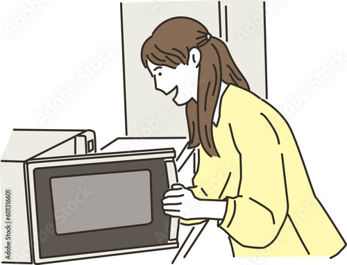 電子レンジを使う若いアジア人女性