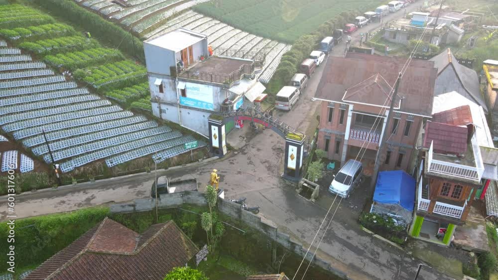Aerial view of the entrance gate from the village of Butuh, Nepal Van Java with golden statue of Mountain climber. Famous tourist village on the slope of Mount Sumbing, Central Java, Indonesia Aerial view of the entrance gate from the village of Butuh, Nepal Van Java with golden statue of Mountain climber. Famous tourist village on the slope of Mount Sumbing, Central Java, Indonesia