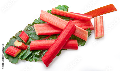 Red rhubarb stems' cuts over rhubarb leaves isolated on white background.