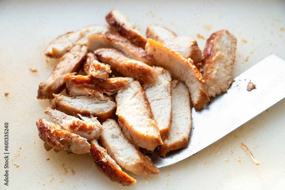 Grilled and sliced chicken breast on white cutting board. Grilled and sliced chicken breast on white cutting board.