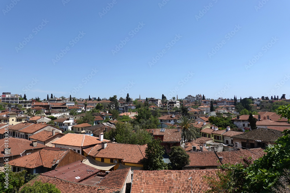 Panoramic view of the tiled roofs of dense standing houses of the Antalya old city from the observation deck on a sunny day