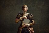 Portrait of young, pretty girl, royal person in vintage dress and modern glasses posing with laptop against dark green background. Business woman. History, renaissance art, comparison of eras concept