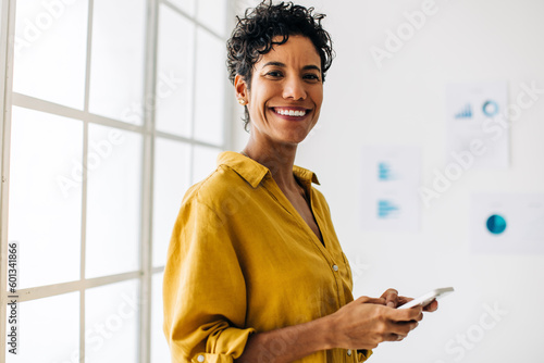 Happy female professional holding a mobile phone in her hand