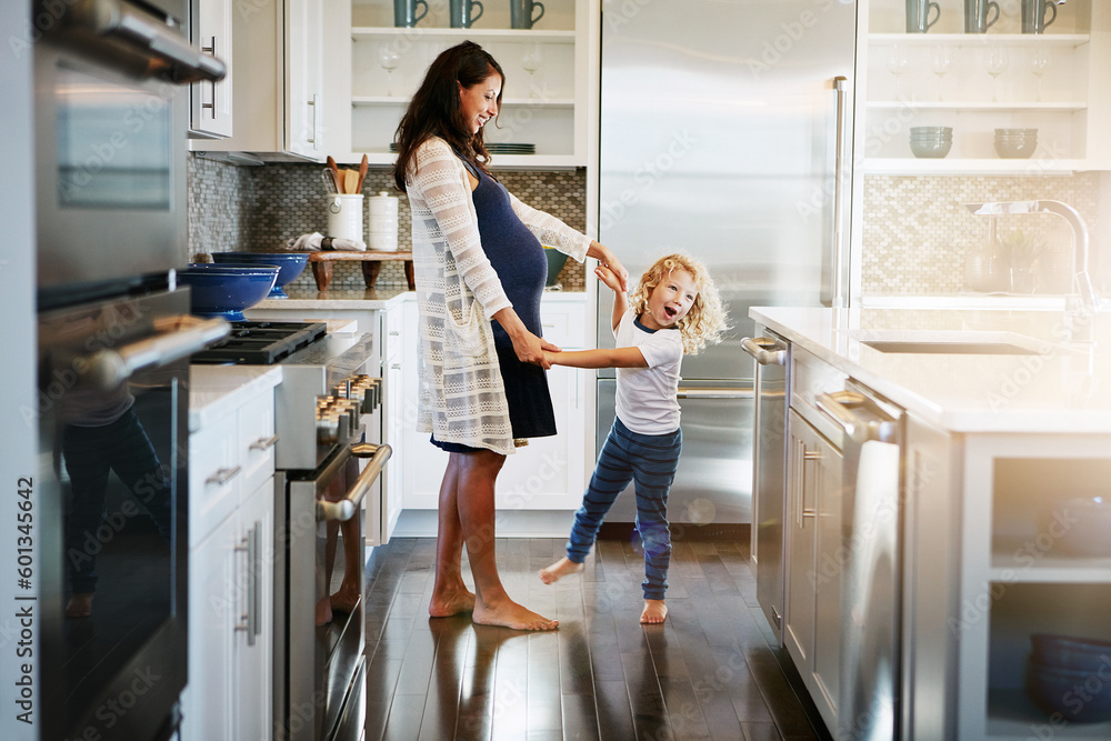 Happy family, pregnant woman with boy child and in kitchen at their home with lens flare. Mother with love or care, mother and cheerful parent with son bonding with dance in their house together - obrazy, fototapety, plakaty 