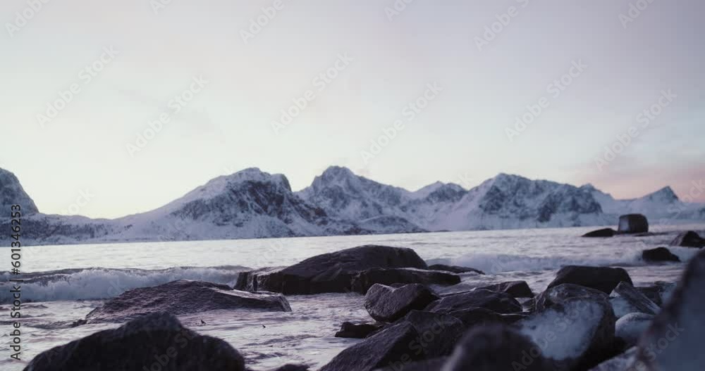 Waves splash on serene coast of fjord at Lofoten islands, Norway Waves splash on serene coast of fjord at Lofoten islands, Norway