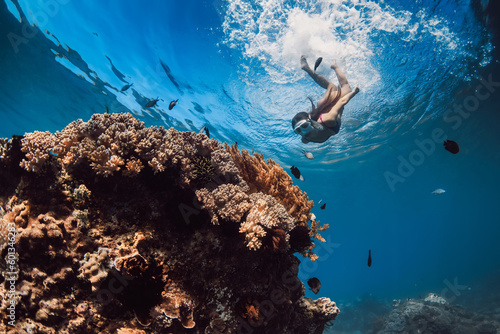 Photo Woman with mask dive to the corals in tropical blue sea