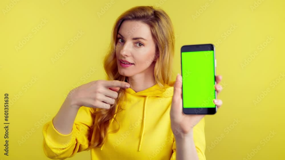 Advertising, green screen, chroma key, Yes gesture and woman with phone for product placement, branding and mobile app marketing. Smiling lady female with mobile smartphone, approval emotion on yellow Advertising, green screen, chroma key, Yes gesture and woman with phone for product placement, branding and mobile app marketing. Smiling lady female with mobile smartphone, approval emotion on yellow