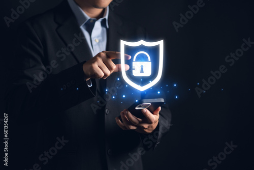 A possible description for this photo might be: "Businessman using his phone to check security hologram lock icon for digital protection and cyber security concept