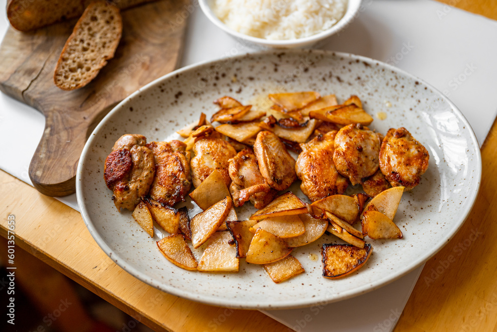Quail breast with roasted sliced pear on plate, rice in bowl, bread on cutting board . Quail breast with roasted sliced pear on plate, rice in bowl, bread on cutting board .