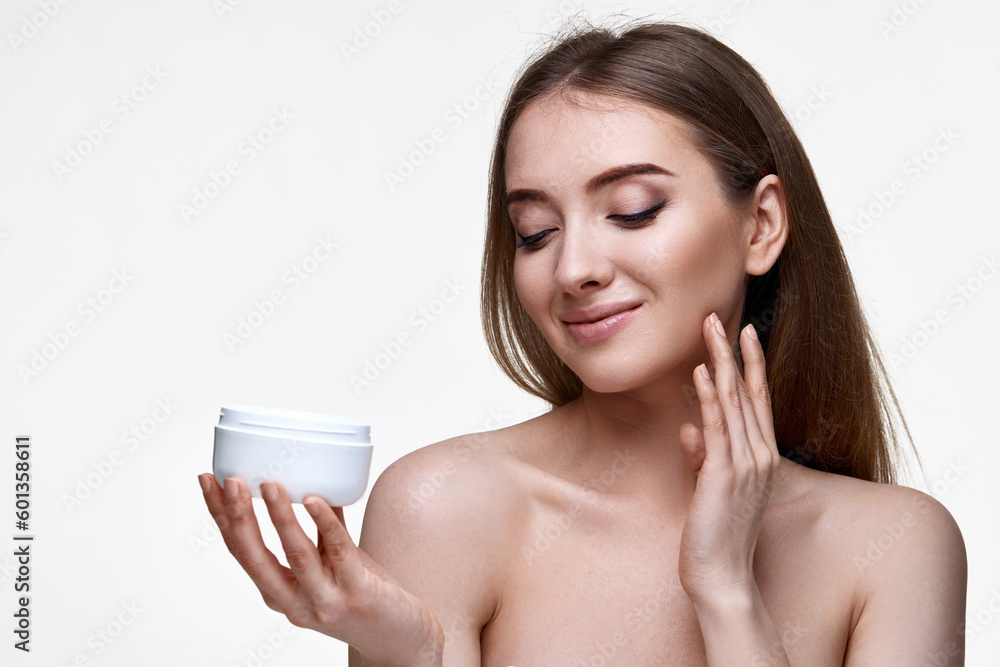 beautiful smiling young woman applying skin care cream on her face beautiful smiling young woman applying skin care cream on her face