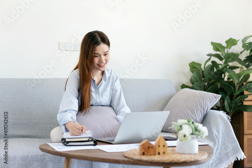 Female freelance is typing to search data on laptop and writing