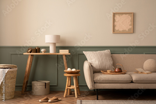 Fototapeta Naklejka Na Ścianę i Meble -  Interior design of cozy living room interior with mock up poster frame, stylish beige fofa, modern armchair, wooden coffee table, wall with stucco and personal accessories. Home decor. Template.