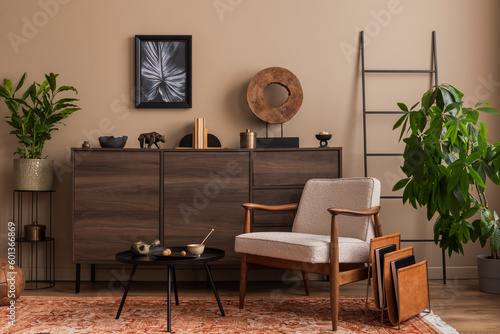 Stylish composition of living room interior with mock up poster frame, boucle armchair, round coffee table, wooden sideboard, plant, ;adder and personal accessories. Home decor. Template. photo