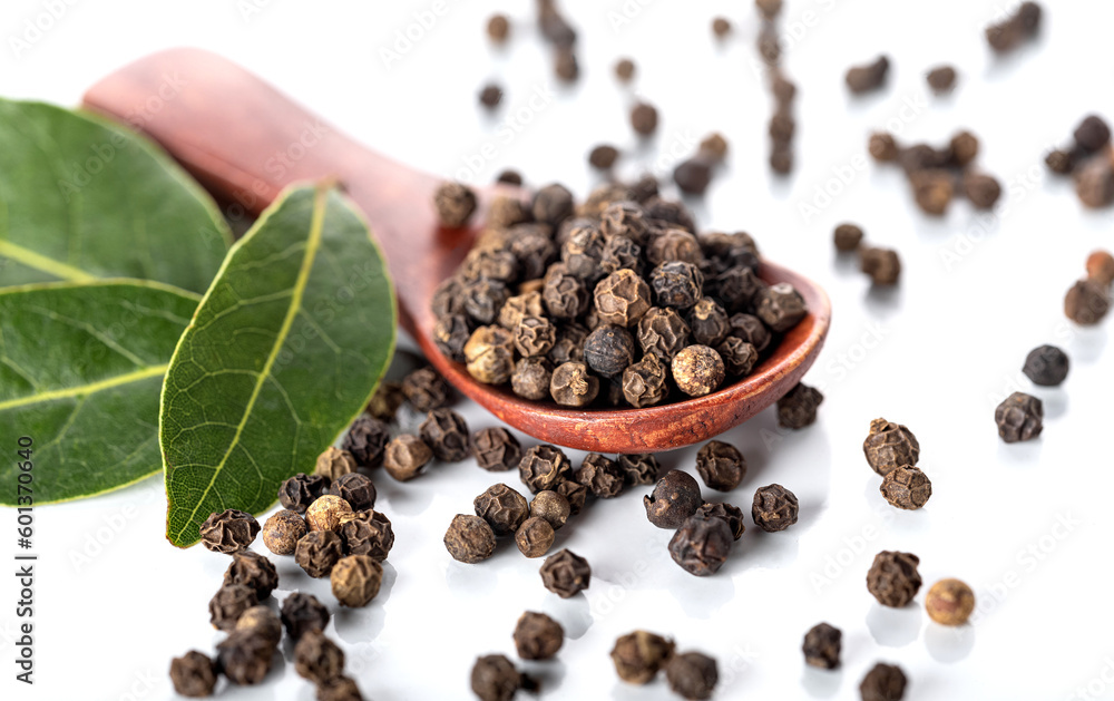 Black pepper and bay leaves isolated on a white background. View from above. Black pepper and bay leaves isolated on a white background. View from above.