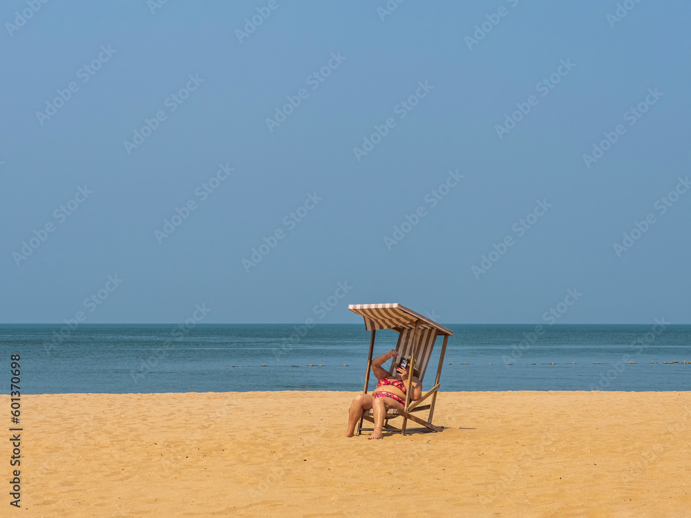 old woman watching Mobile social media happily on a private beach. old woman watching Mobile social media happily on a private beach.