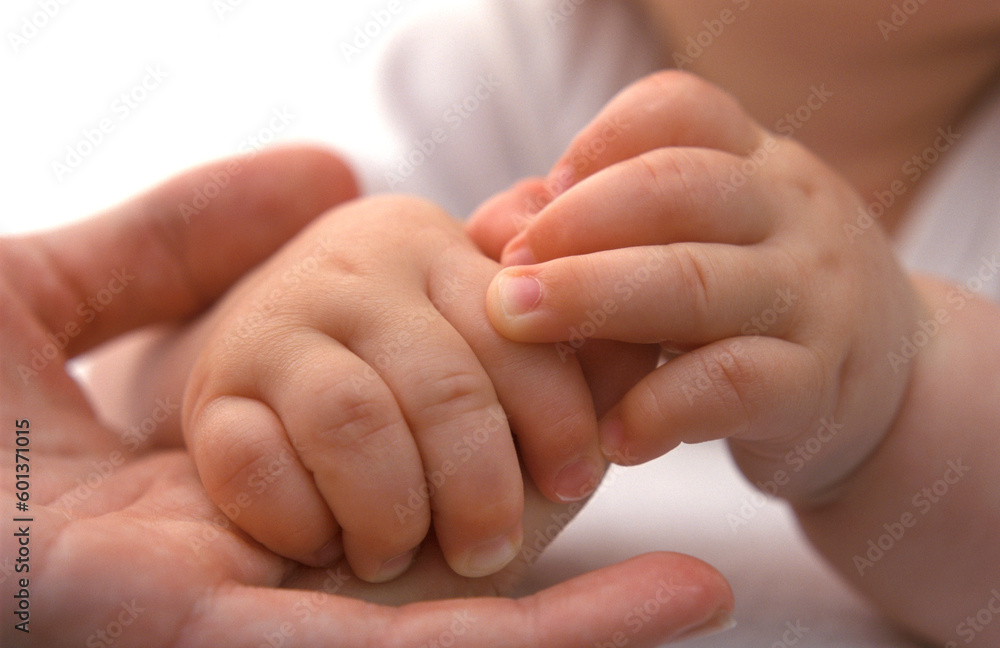 Tiny baby hands holding mothers finger close up Tiny baby hands holding mothers finger close up