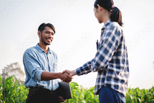 Two smart farmers shaking hands to celebrate after examining qua