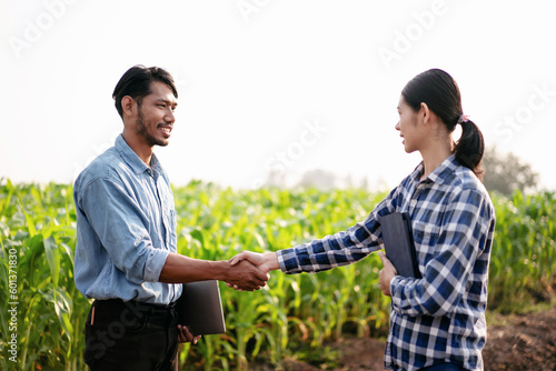 Two smart farmers shaking hands to celebrate after examining qua photo