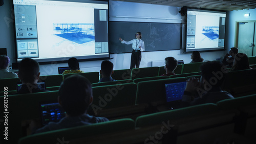 Young Female Teacher Giving an Architectural Engineering Lecture to Diverse Multiethnic Group of Women and Male Students in Dark College Room. Projecting Slideshow with a Private House Blueprint