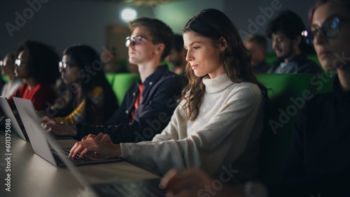 Beautiful Smart Female Student Studying in University with Diverse Multiethnic Classmates. She is Using a Laptop Computer. Applying Her Knowledge to Acquire Academic Skills in Class