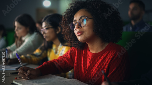 Talented Smart Multiethnic Hispanic Female Student Studying in College with Diverse Colleagues. Black Young Woman Writing Down a Summary from the Lecture in Her Notebook